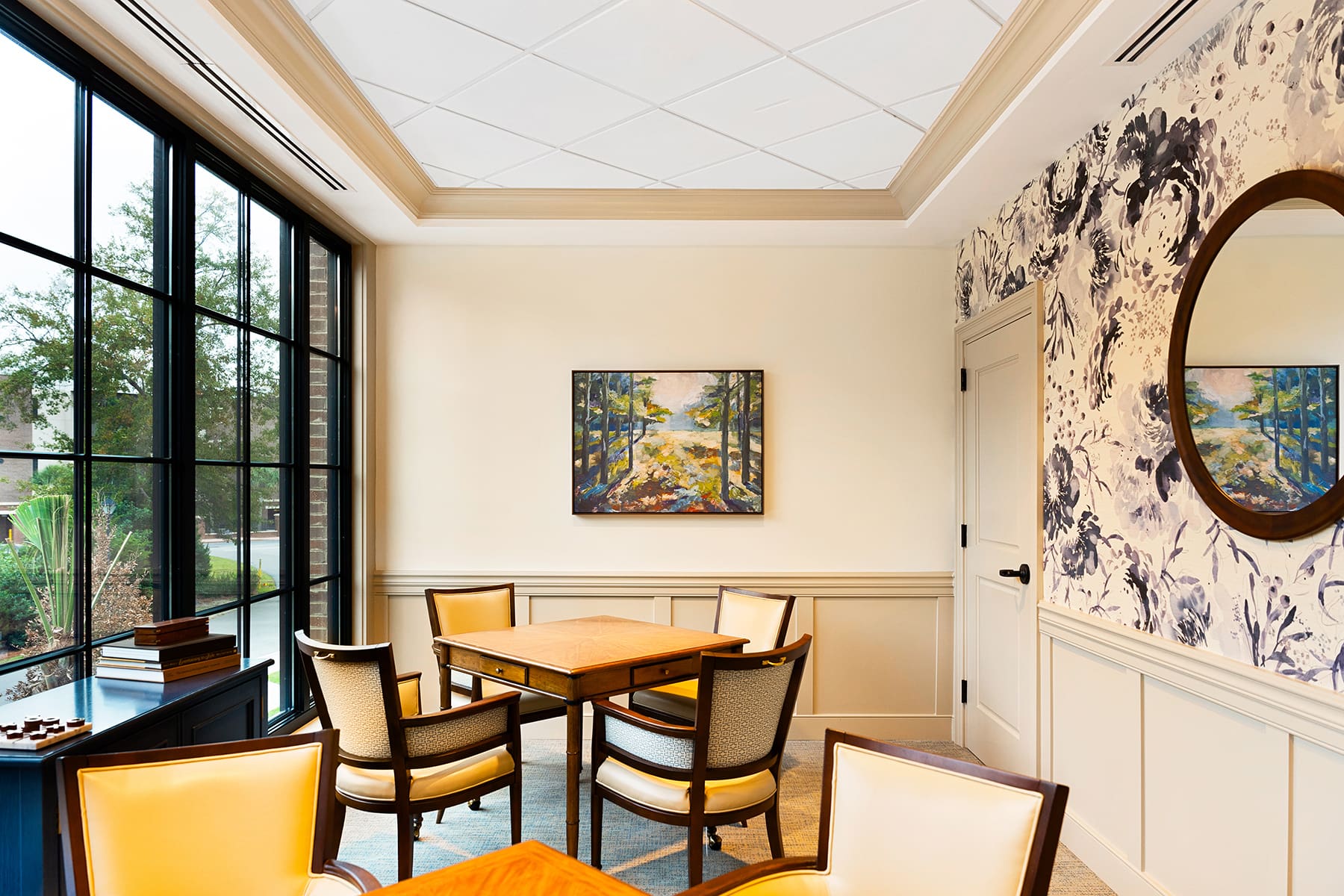 Elegant dining room with large windows, wooden table, upholstered chairs, and decorative wallpaper