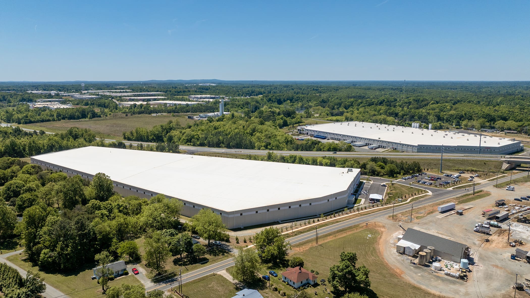 Aerial view of large industrial warehouse and surrounding landscape