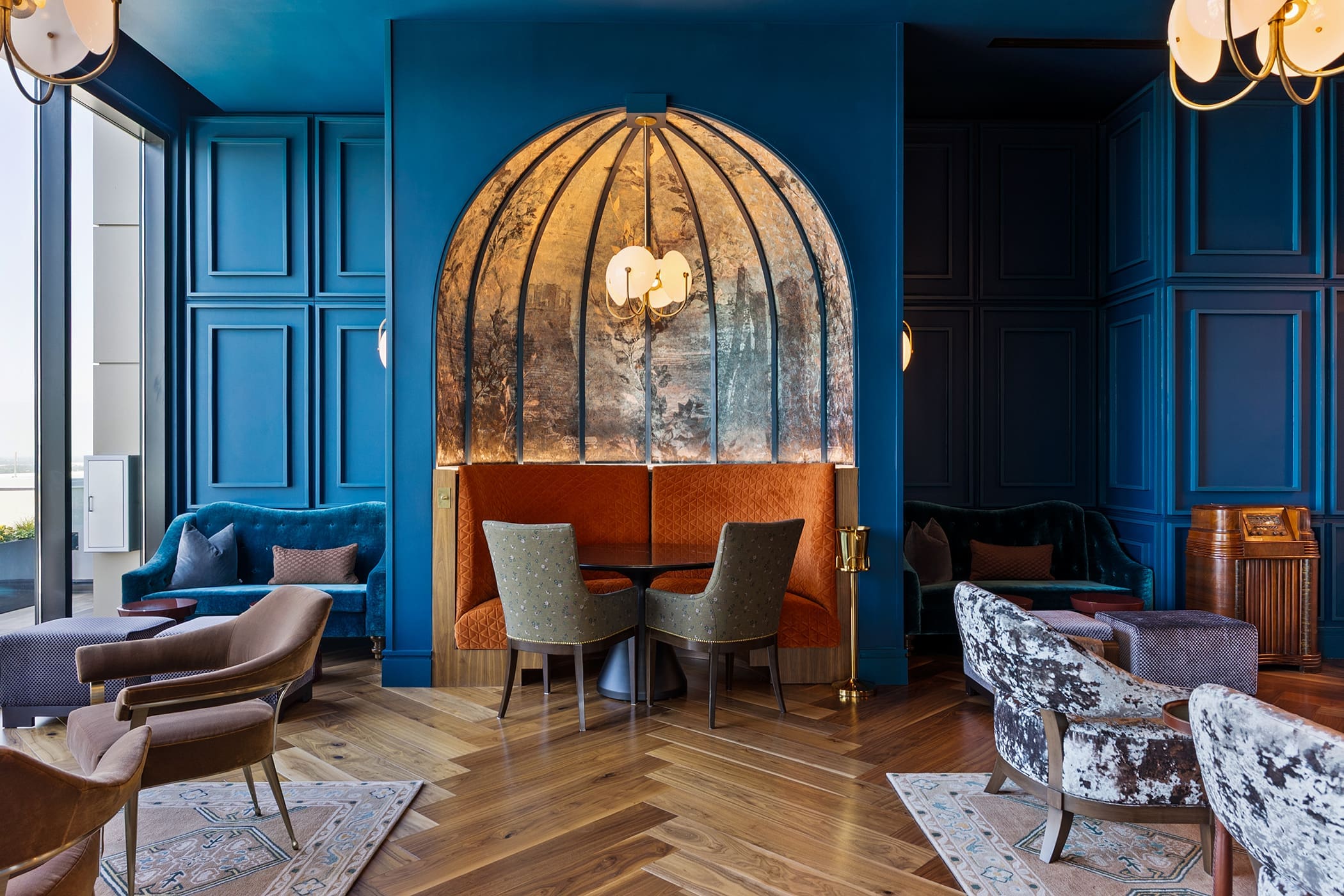 Luxury lounge area with blue accent walls and woven hanging chair